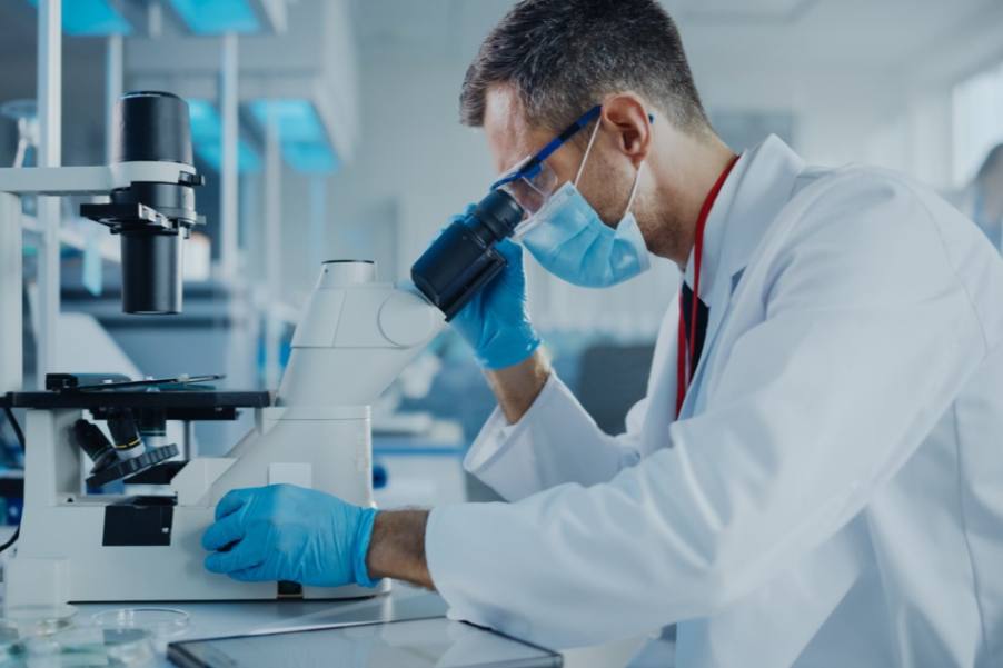 Male researcher looking through a Microscope